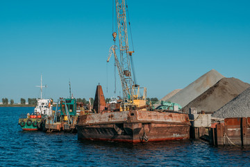 Obraz premium Industrial cargo port with old ships on river, water logistics