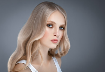 Fototapeta premium Beautiful Woman Face Portrait Beauty Skin Care Concept with long blonde hair over gray background