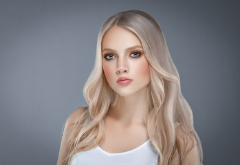 Beautiful Woman Face Portrait Beauty Skin Care Concept with long blonde hair  over gray background