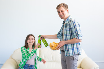 Attractive young loving couple drinking beer at home