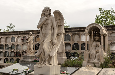 Sepulchral sculptures on graves in Poblenou Cemetery. Peaceful but macabre, cemetery of Poblenou is...