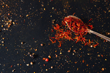 Saffron spice in spoon with empty space for text on dark black background. Seasonings for food....