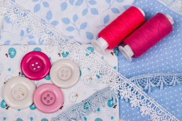 Fototapeta na wymiar Multicolored threads, buttons on blue fabric