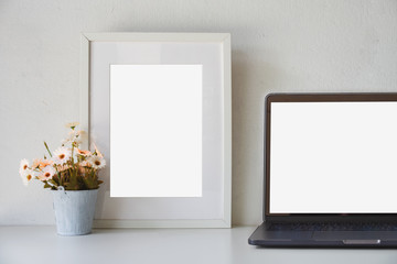 Mockup loft workspace, Blank screen laptop and mockup poster at white desk.