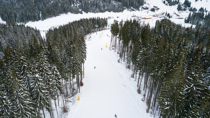 Skiers and snowboarders go down the slope in a ski resort Bukovel, Ukraine