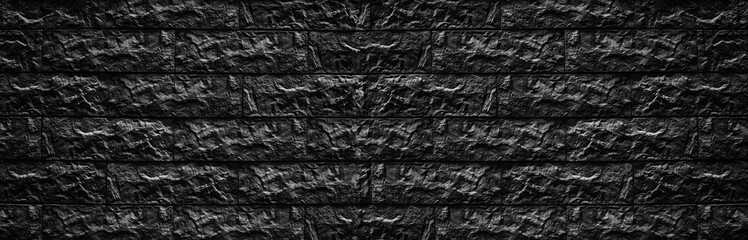 Wide black brick wall texture - stone blocks masonry background