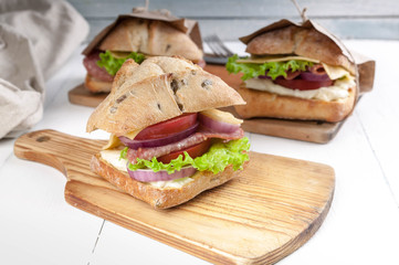 Ciabatta sandwich with prosciutto, tomato, salad and cheese.