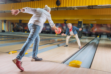 At the weekends. Delighted nice men having fun together while meeting in the bowling club