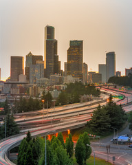 Busy traffic on I-5 Freeway at I-90 interchange during afternoon rush hour with Seattle skylines in...