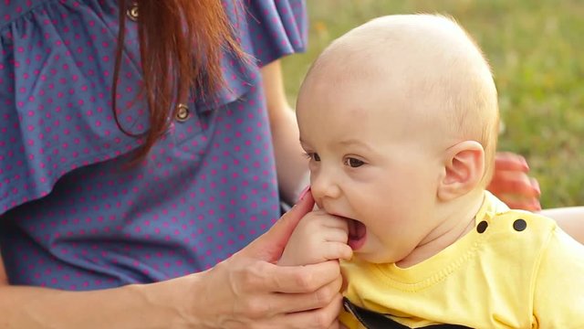 Teething baby biting fingers, close-up