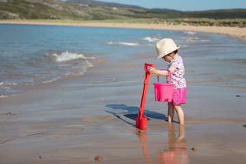 baby girl playing at summer beach