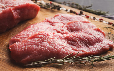 Raw beef filet mignon steaks on wooden board
