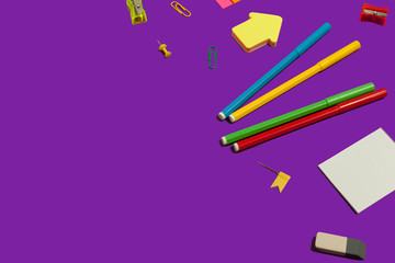 set of various school and office supplies lying on a purple background. free copyspace