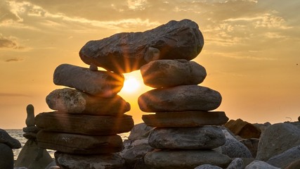Pyramid of the stones isolated on sunset, seaside background