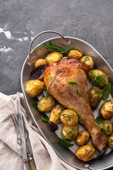 Grilled spicy turkey legs with potatoes on a black background. Copy space.