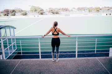 young atheltic woman looking at sports field