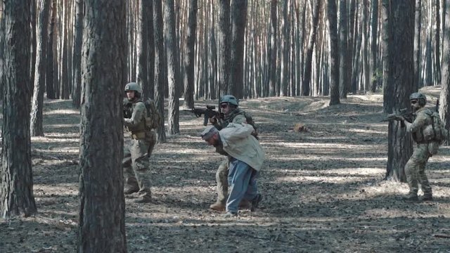 Soldiers of the United States escort a captured mujahid terrorist in the forest