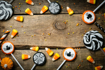 Fototapeta na wymiar Halloween background - candies and lollipops, straws, wood background