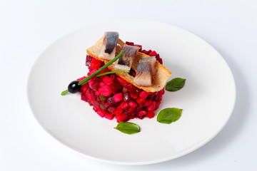 Herring with beetroot salad on white plate, gourmet restaurant serving