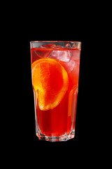 A single-colored transparent cocktail, refreshing in a tall glass with ice cubes, orange slice, lemon and taste of berries, cherries, strawberries, greiprut. Side view. Isolated black background