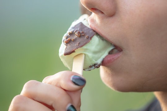 The Girl Is Eating Ice Cream On A Stick