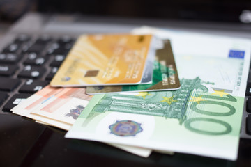 close up Euro banknotes and credit cards on laptop keyboard