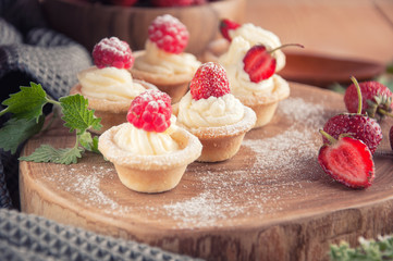 Tartlets with cream, raspberries, strawberries.