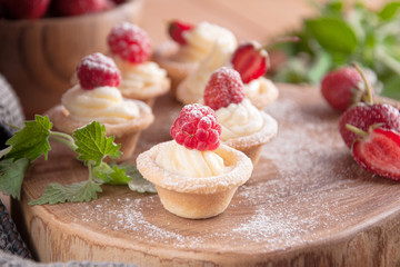 Tartlets with cream, raspberries, strawberries.