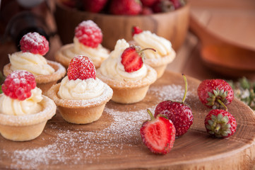 Tartlets with cream, raspberries, strawberries.