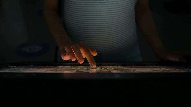 Woman using interactive touchscreen display at modern history museum. Education and technology concept