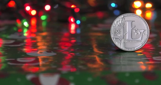 Golden Bitcoin currency. Festive atmosphere. Colorful Christmas tree lights in the background. BTC is a cryptocurrency and is the first decentralized peer-to-peer payment network.4K, Panning, Closeup.