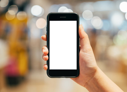 Woman hand holding mobile smart phone isolated white screen with beautiful light bokeh background