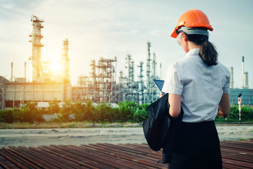 The engineer is standing on large industry background.