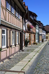 Fototapeta premium Kleine Gasse mit Fachwerkhäusern und Kopfsteinpflaster in Wernigerode