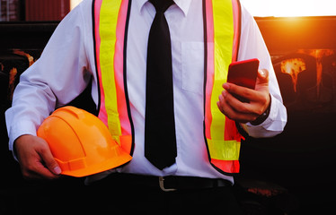 The engineer is working with smart phone with large industry background.
