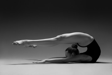 Flexible girl in leotard. Black and white photo.