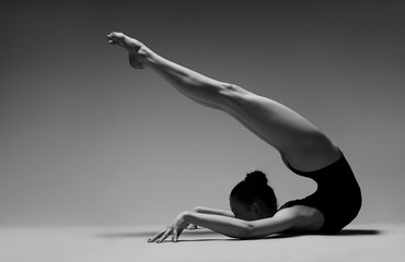 Flexible girl like a scorpion. Black and white photo.