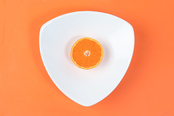 Mandarin Orange Fruit slice half juiced extracted on hart shape plate orange background