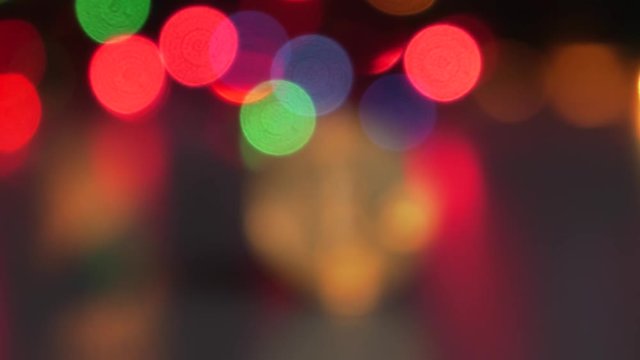 Golden Bitcoin currency. Festive atmosphere. Colorful Christmas tree lights in the background. BTC is a cryptocurrency and is the first decentralized peer-to-peer payment network.4K, Panning, Closeup.