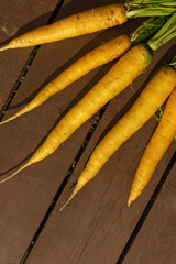 A bunch of clean fresh carrots on a wooden background