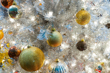 Close up of white Crhistmas tree with golden glittery Christmas balls