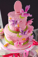 luxury delicious pink cake with colorful butterflies and candy bar at celebration, party in a restaurant