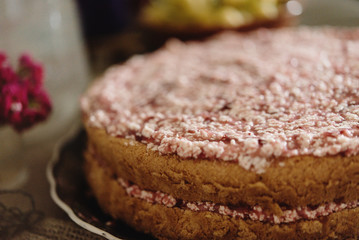 closeup of delicious strawberry cake with pink cream on rustic background, rural summer concept