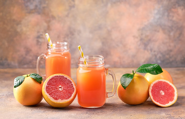 Naklejka na ściany i meble Two jar of fresh grapefruit juice on a abstract background.Selective focus.
