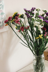 colorful amazing wildflowers in vase on background of rustic room