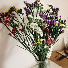 colorful amazing wildflowers in vase on background of rustic room