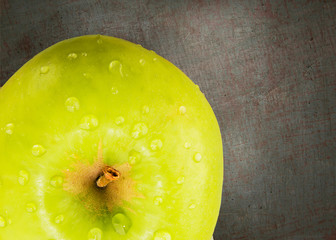 Green aple with water drops.  Top view with copy space on dark background.