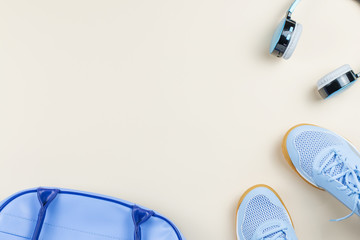 Woman sneakers, headphones, sport bag on pastel background. Sport fashion concept. Flat lay