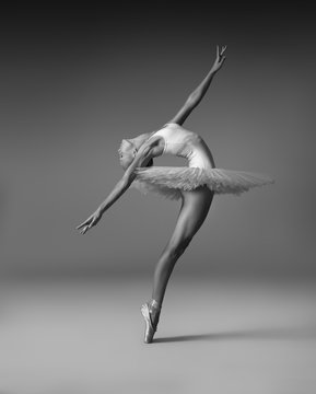 Fototapeta Ballerina in a tutu and pointe shoes makes a beautiful pose