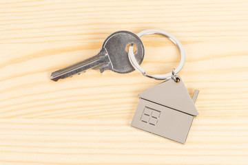 House key on wooden background concept for mortgage